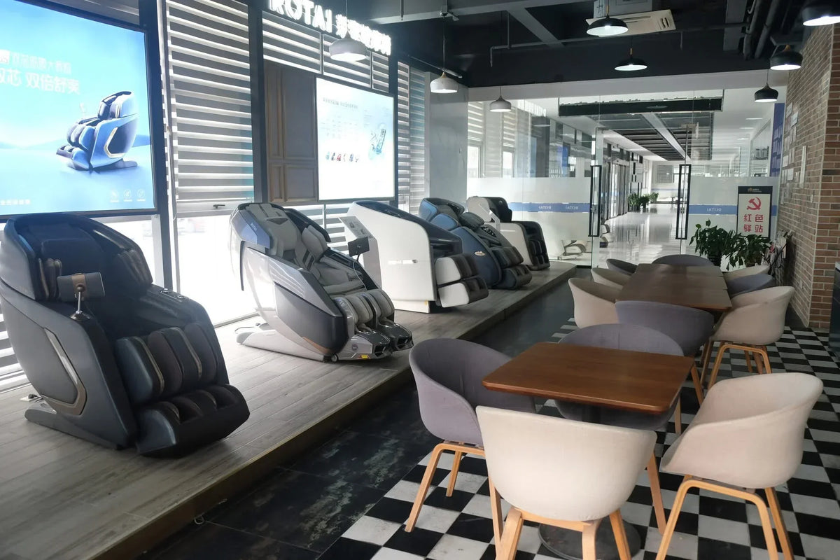 Modern massage chairs displayed in a sleek showroom with seating area, ideal for relaxation and wellness.