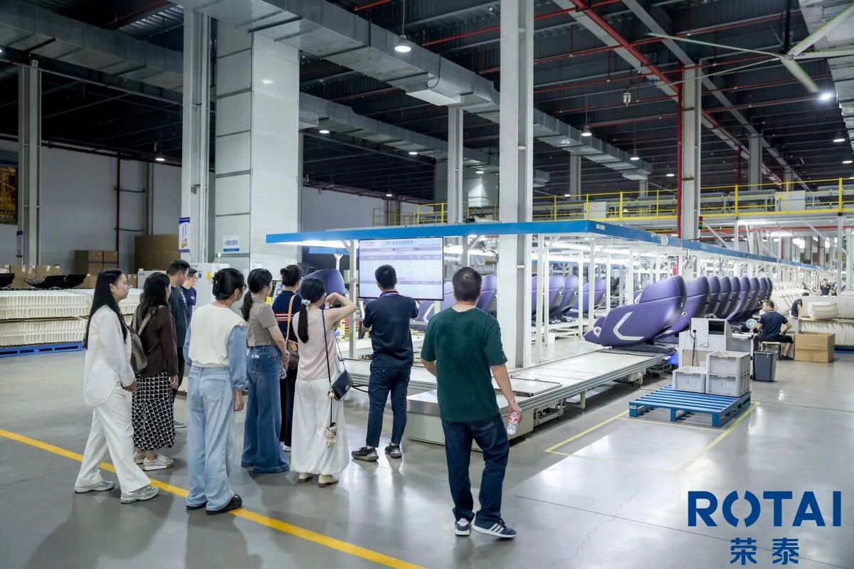 Visitors touring a ROTAI massage chair production line
